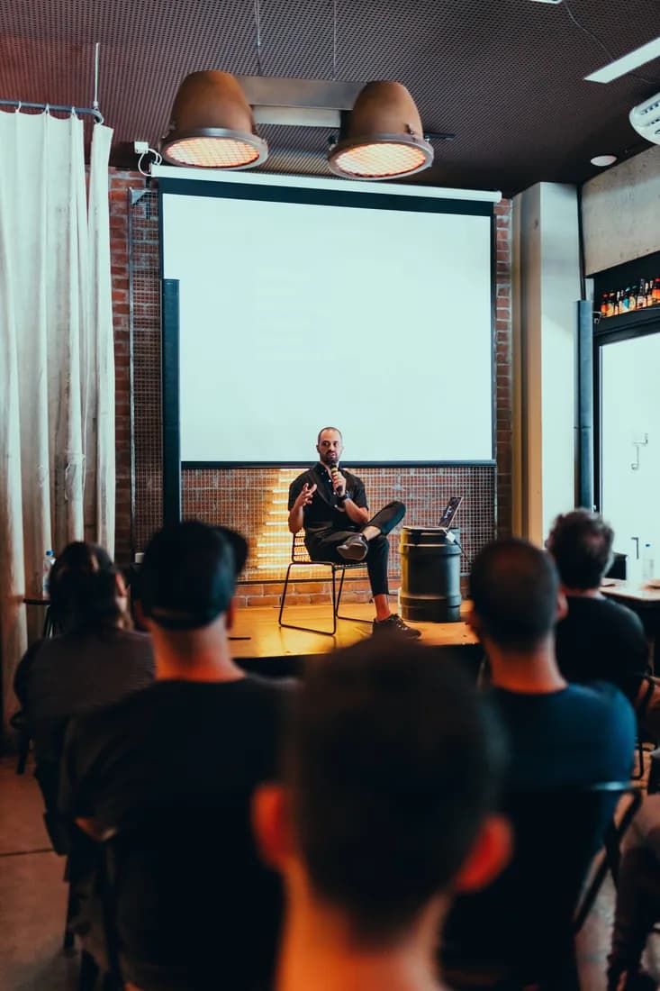 A speaker presenting to a professionally staged audience